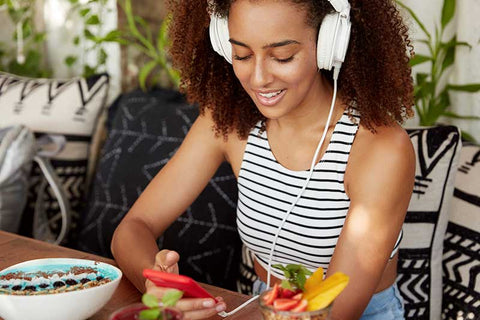 Selección de podcasts gastronómicos reproducidos en un móvil y unos auriculares sobre una mesa.